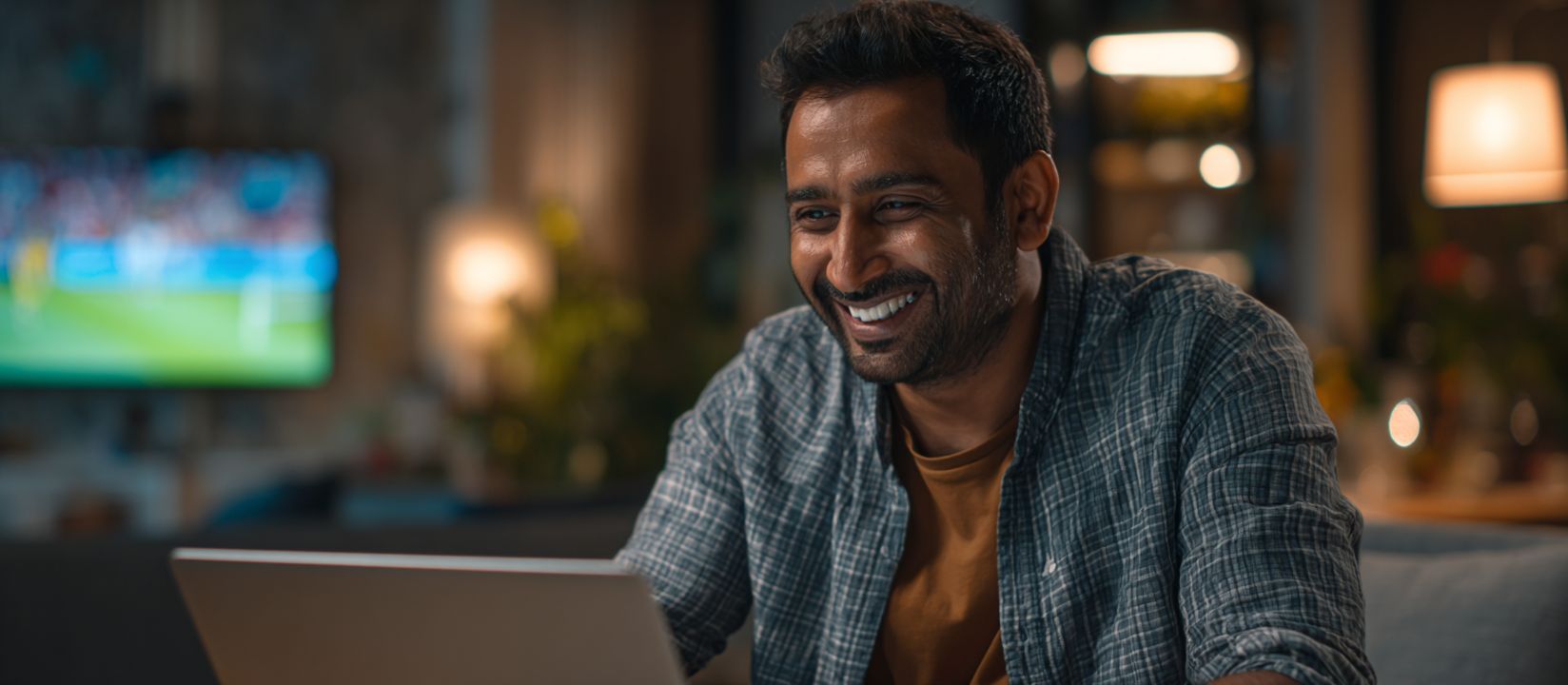 Kikriya Bet – The number one choice for sports betting in Bangladesh Man enjoying Kikriya sports betting on his laptop while watching a live football match